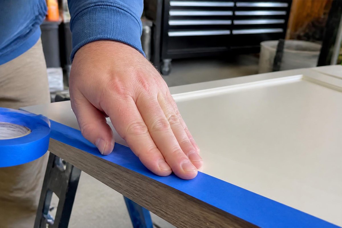 applying painters tape along a clean edge before spray painting